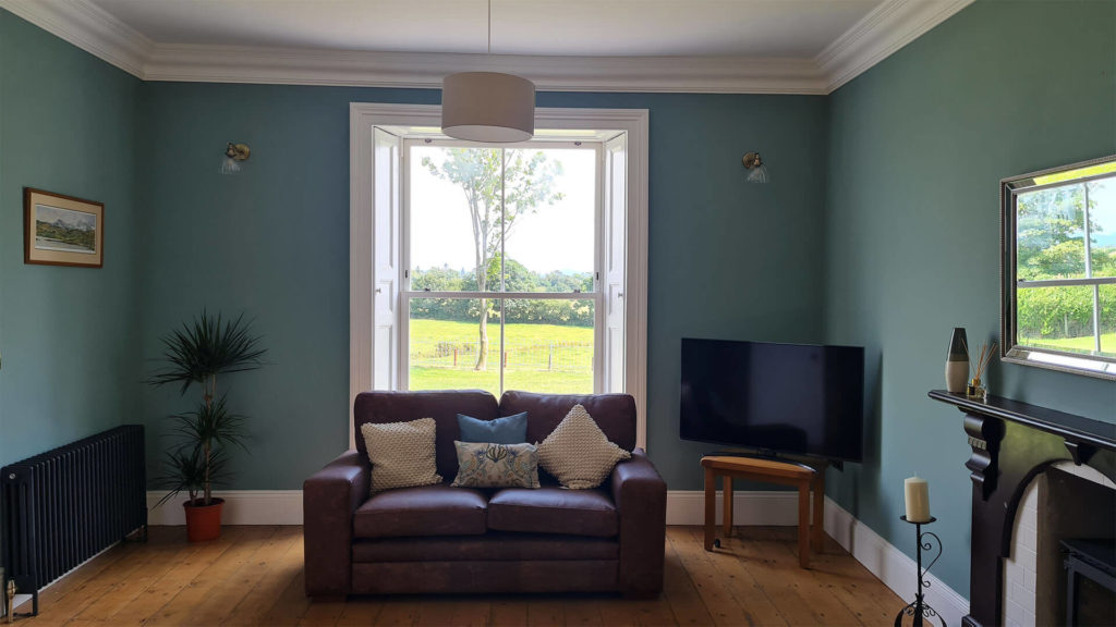 Sitting room with shutters and Fairco Heritage Sash Windows